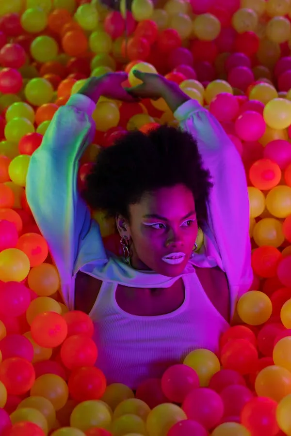 Woman in a Ball Pit Surrounded by Colorful Plastic Balls