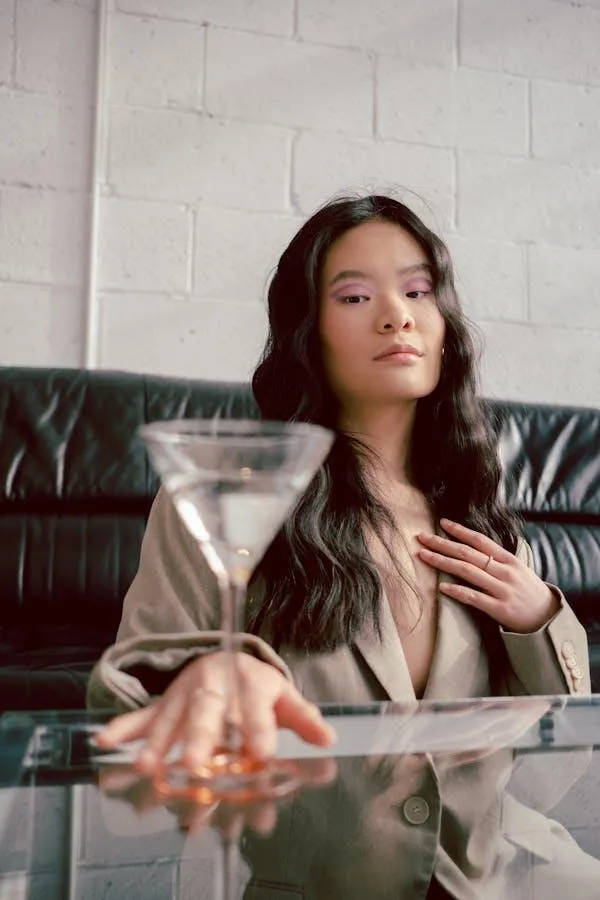 Woman in a Beige Blazer Sitting At a Glass Table Inside