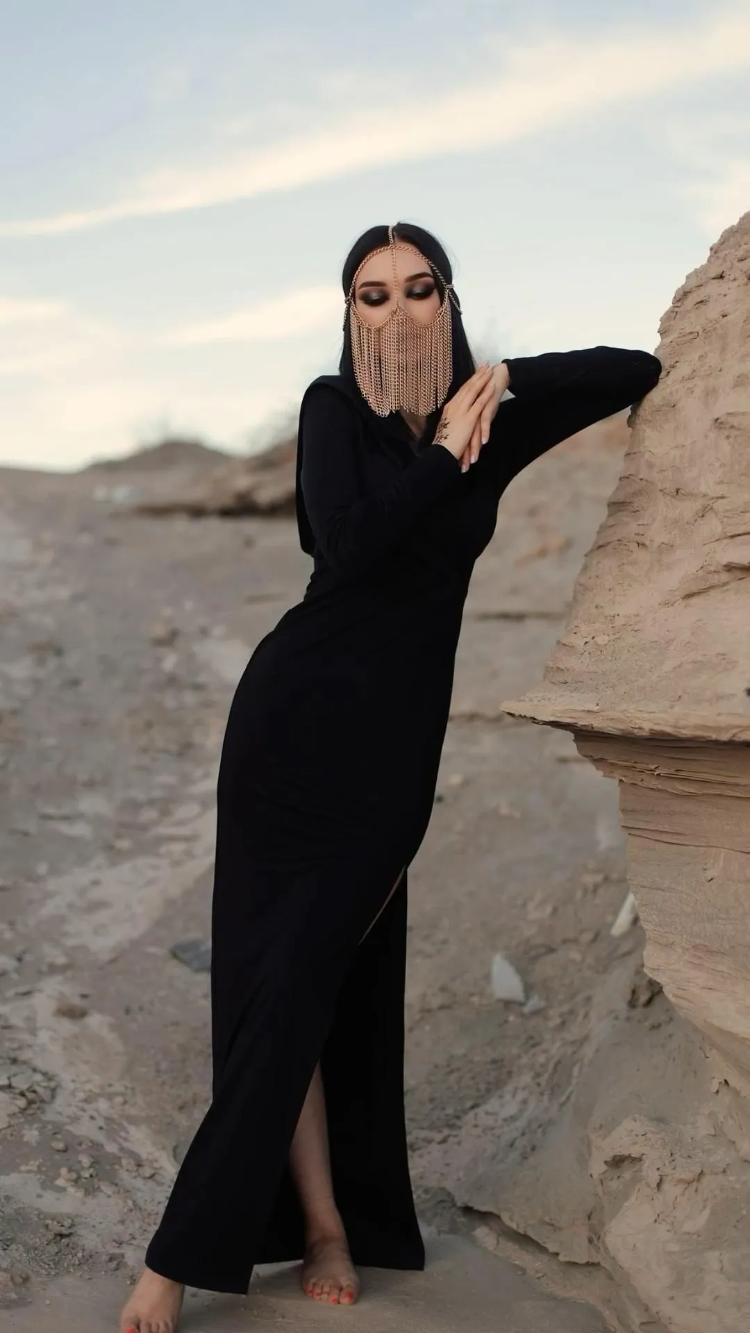 Woman in a Black Dress Standing Confidently on a Desert Rock