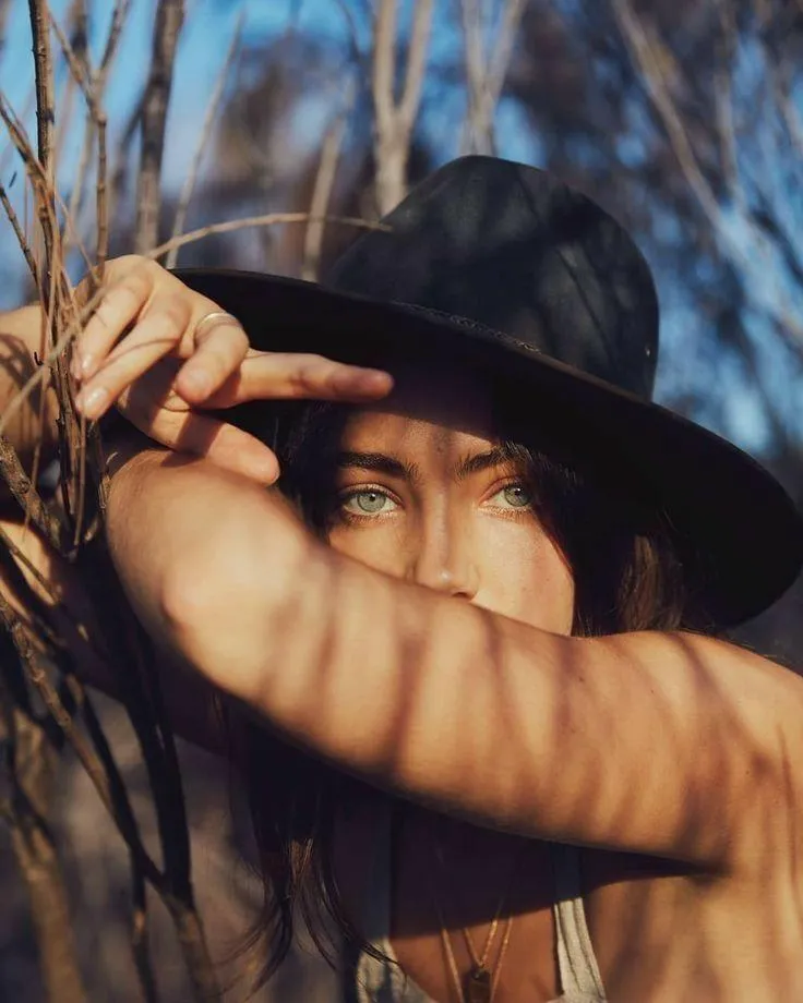 Woman with Black Hat Casting a Shadow on Her Face Wallpaper