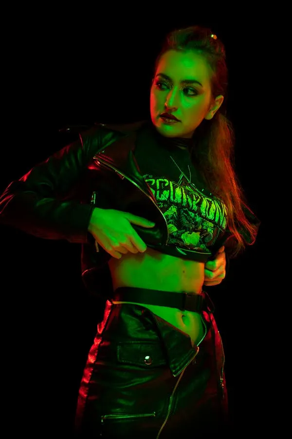 Woman in Black Outfit Striking a Bold Pose with Dark Lighting