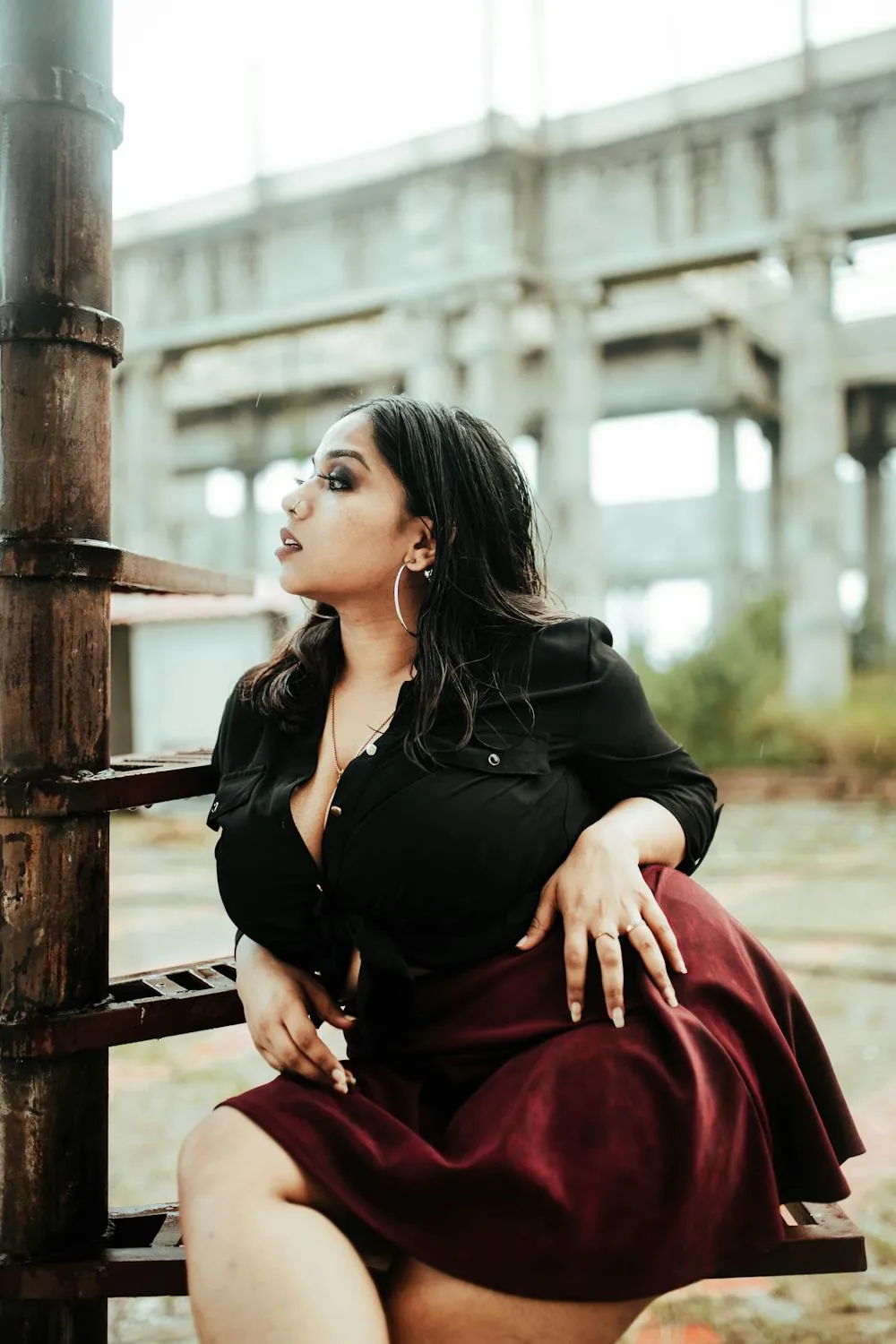 Woman in Black Top and Red Skirt Near Columns Free Wallpaper