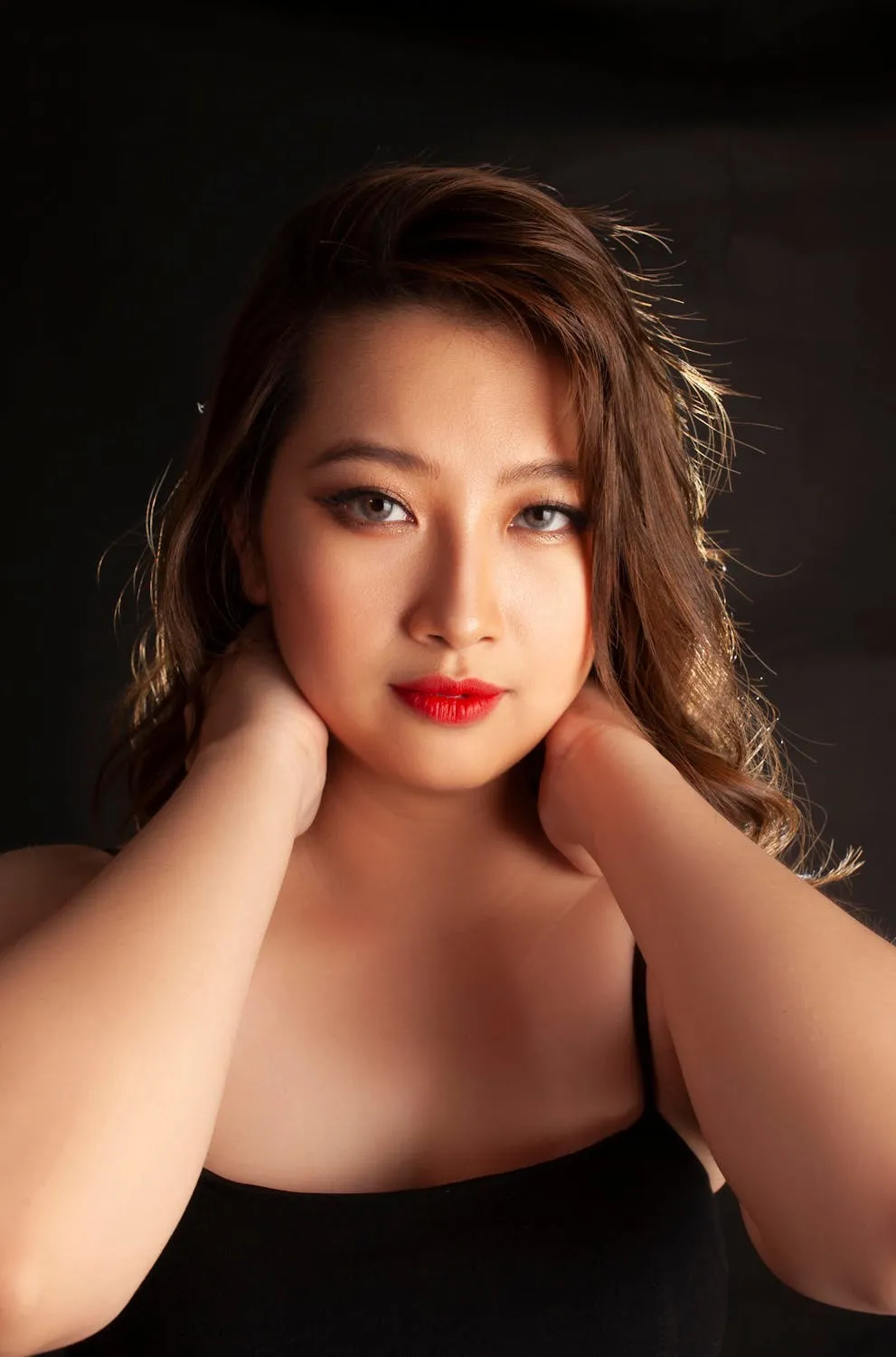 Woman in a Black Top Resting Chin on Her Hand Looking Serene