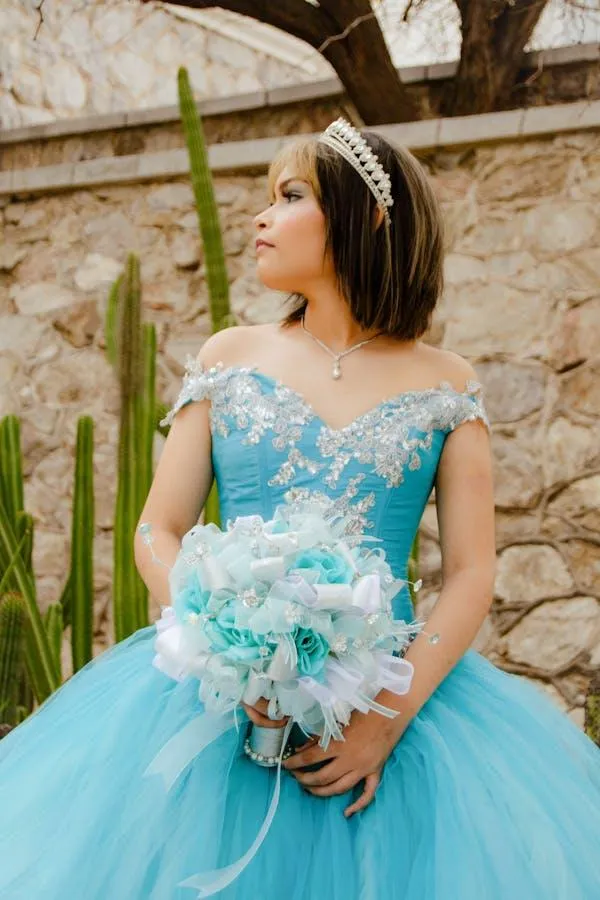Woman in a Blue Dress Holding a Bouquet Standing Outdoors