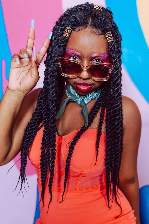 Woman with Braids and Pink Glasses Giving Peace Sign Pose