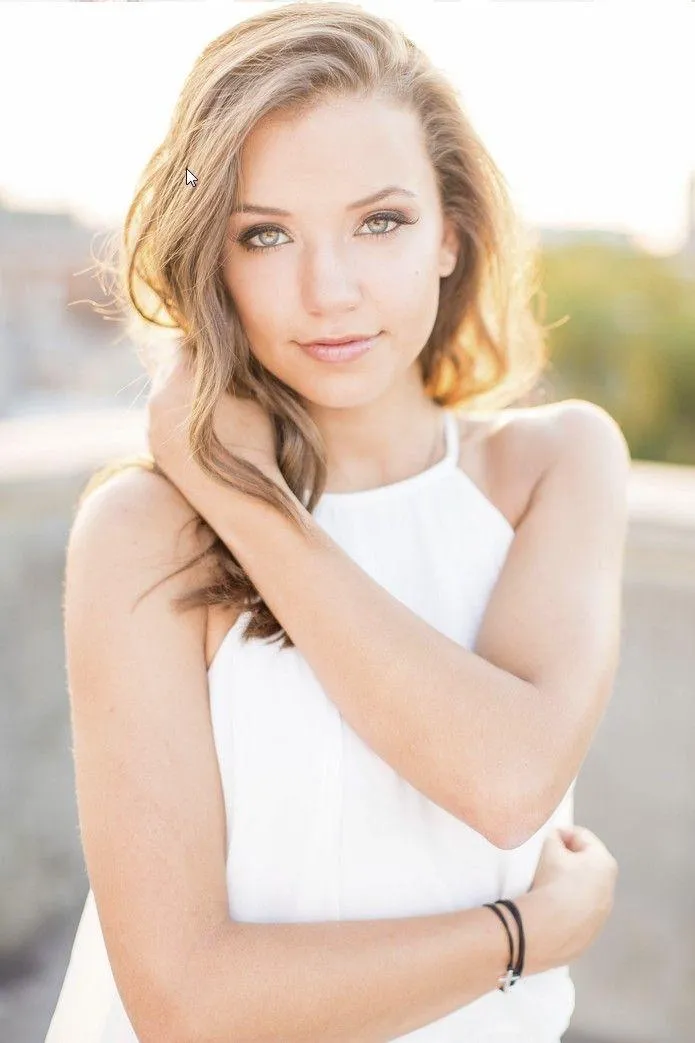 Woman in a Casual Tank Top Standing Near a Dark Modern Wall