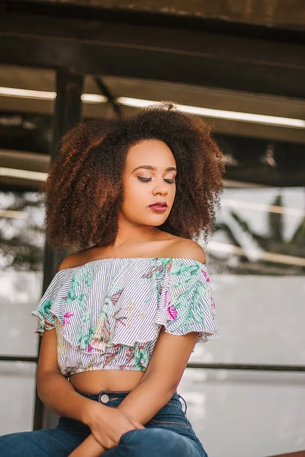 Woman in a Colorful Top and Jeans Sitting Casually Outdoors