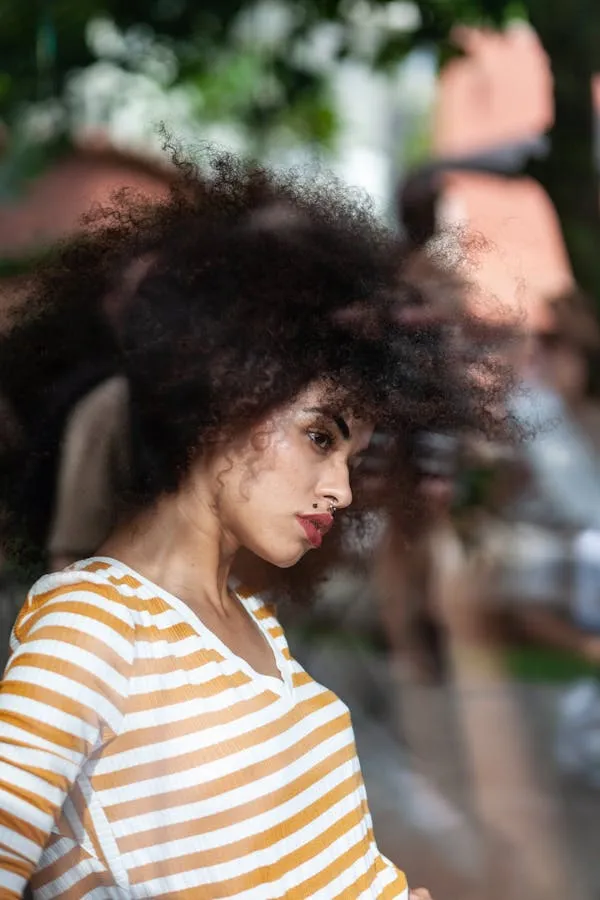Woman with Curly Hair Wearing Orange Striped Shirt Indoors