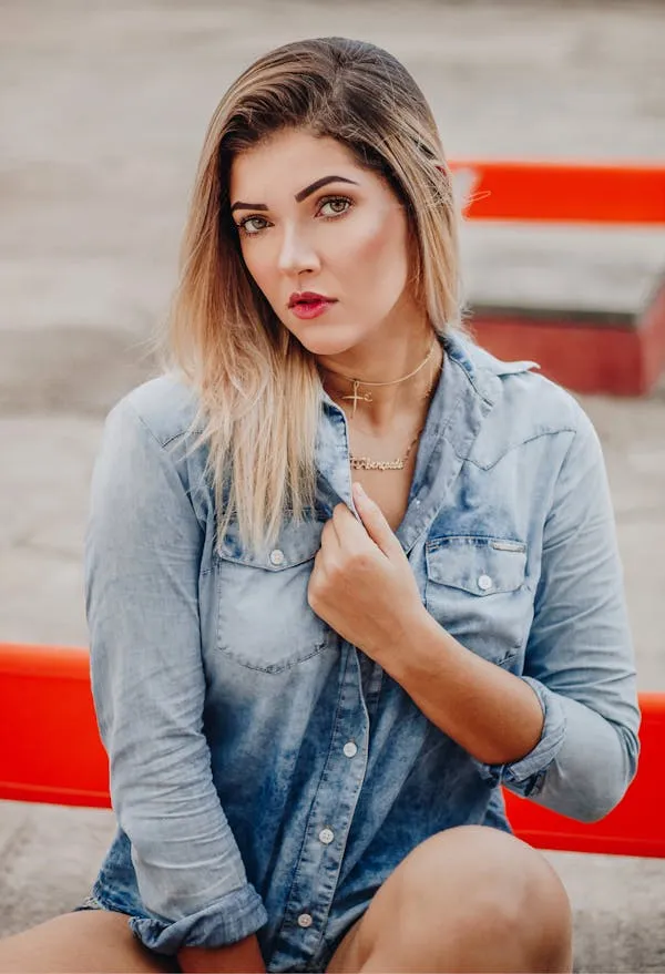 Woman in a Denim Shirt Posing Confidently with Bold Red Lips