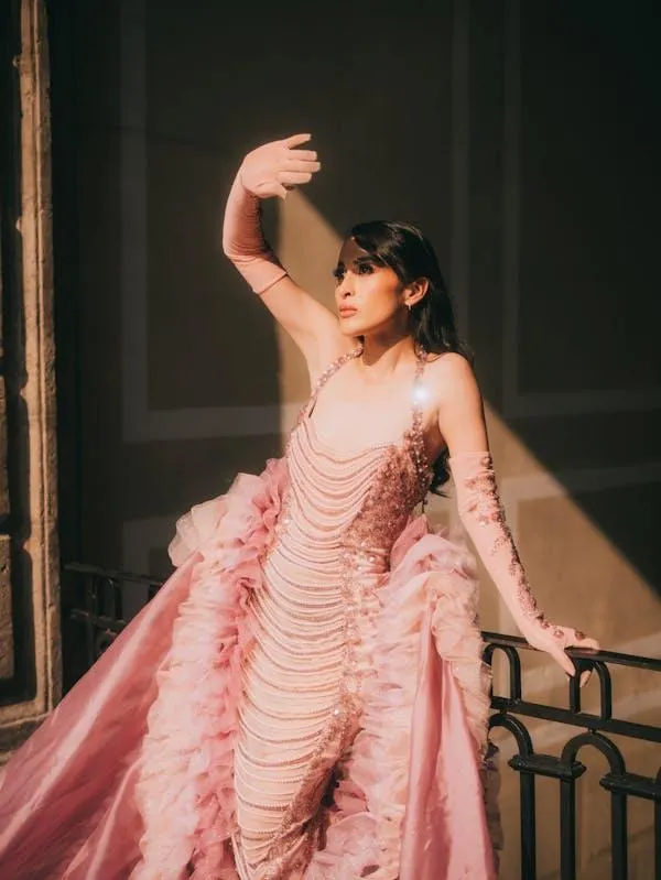 Woman in Elegant Pink Gown Posing on Grand Outdoor Stairs
