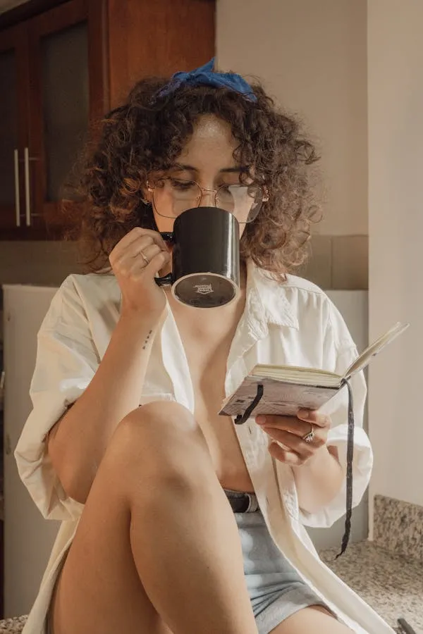Woman Enjoying Coffee and Using a Phone in a Relaxed Setting