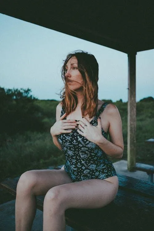Woman in a Floral Dress Sitting Outdoors Under Soft Light
