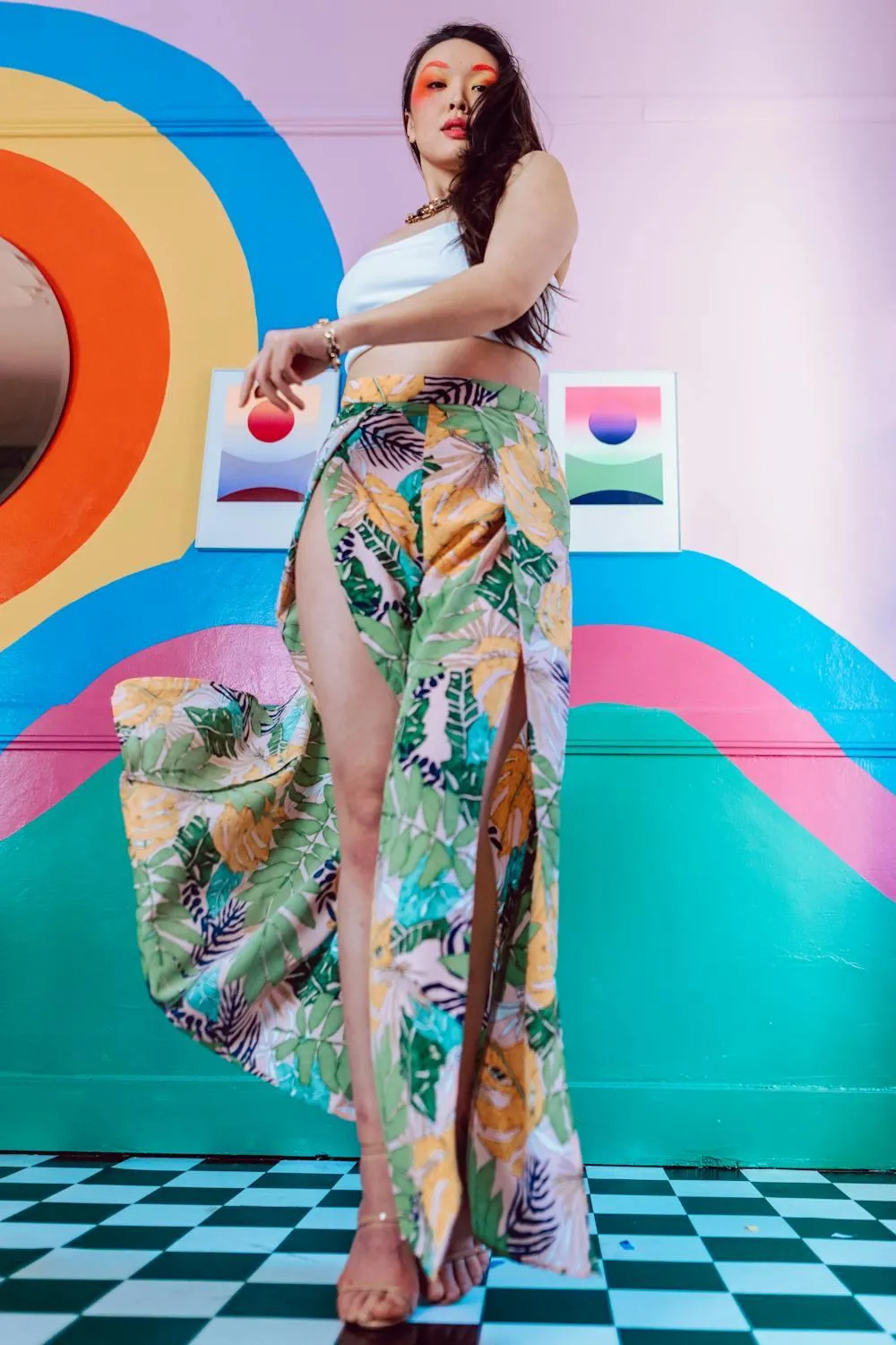 Woman in a Floral Pants Posing in Front of a Colorful Wall