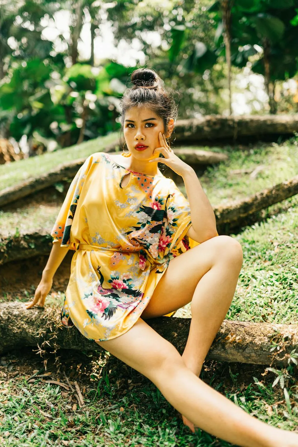 Woman in a Floral Robe Sitting Outdoors in a Tropical Area