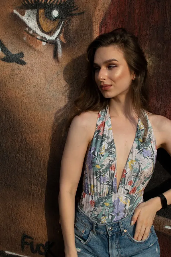 Woman in Floral Shirt Posing Near a Wall with Graffiti Art