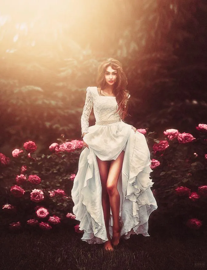 Woman in a Flowing White Dress Surrounded by Pink Flowers
