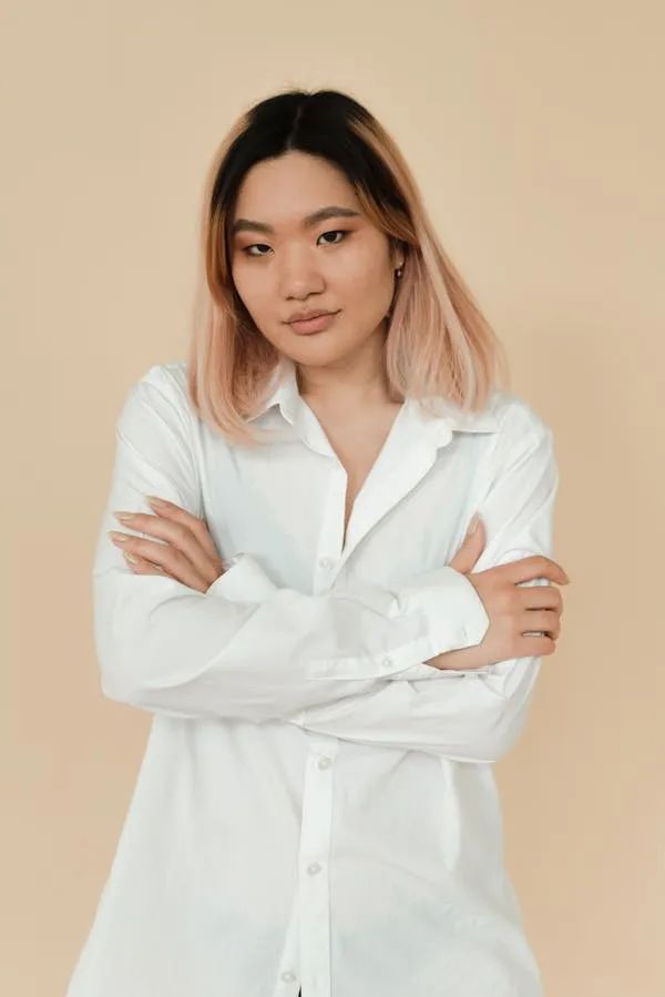 Woman with Folded Arms Standing Confidently in a White Shirt