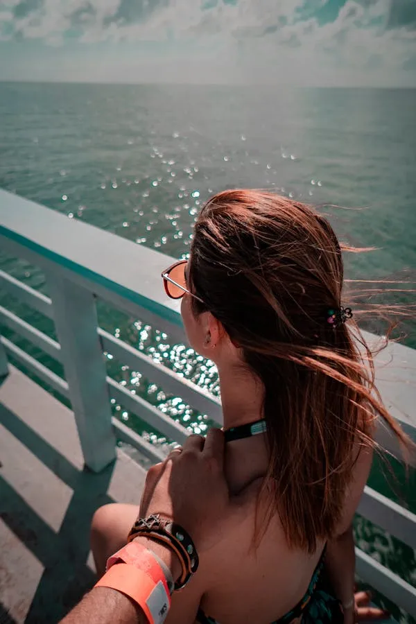 Woman Gazing At the Sea From the Boardwalk Under Bright Sky