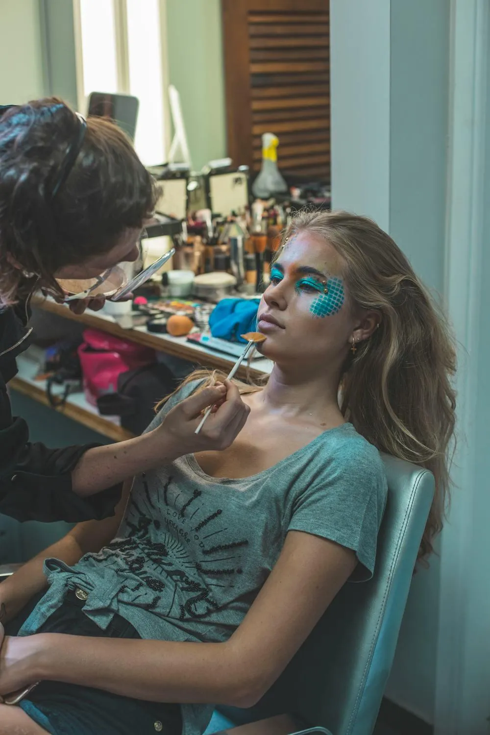 Woman Getting Makeup Done Sitting in Front of a Mirror Light