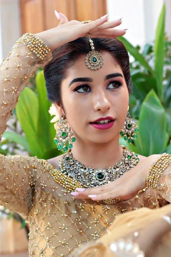 Woman in a Gold Attire with Jewelry Posing in the Sunlight