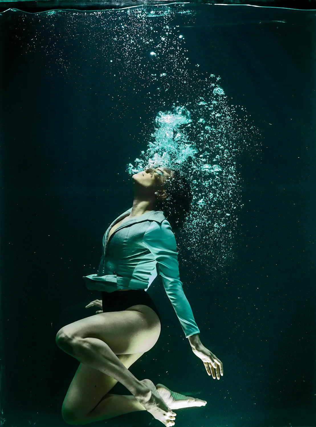Woman Gracefully Underwater with Bubbles and Flowing Clothes