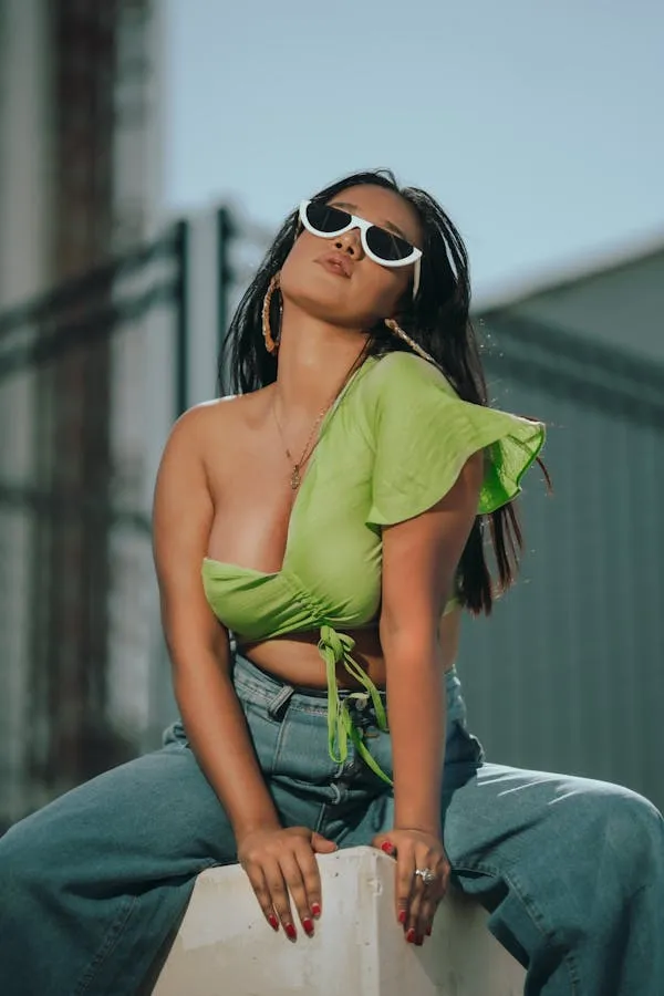 Woman in Green Top and Sunglasses Posing Outdoors Wallpaper