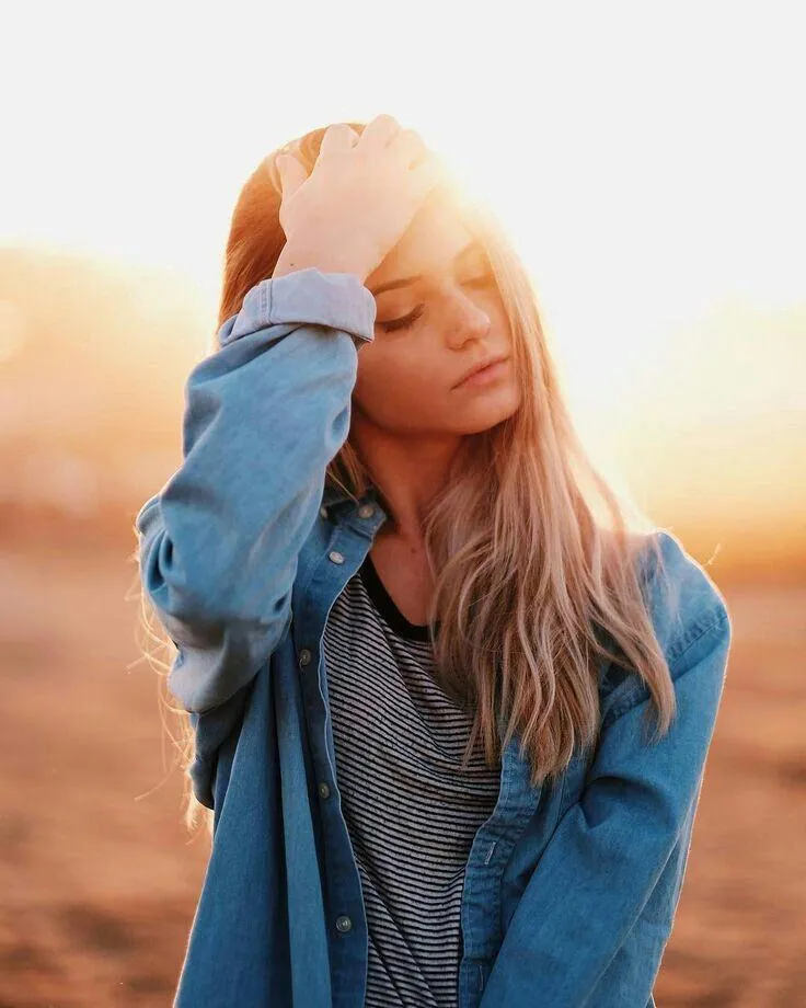 Woman with Hand on Head Posing in Warm Sunset Light Image