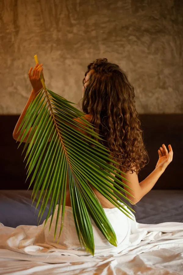 Woman Holding Green Leaf with a Textured Brown Backdrop