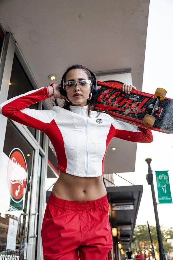 Woman Holding a Skateboard Posing in an Urban City Wallpaper