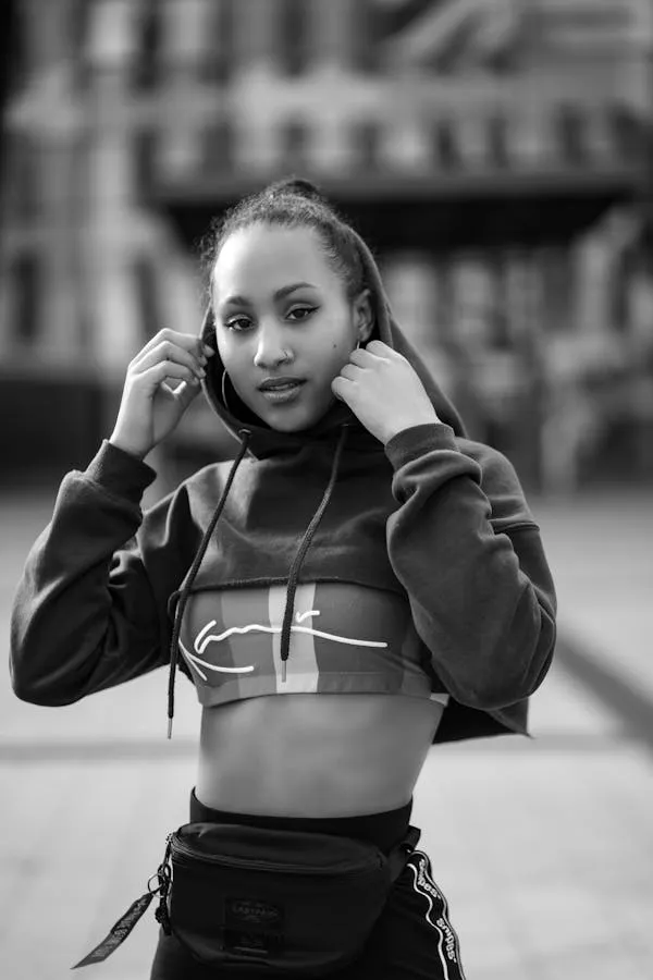 Woman in a Hoodie Posing in a Black and White Urban Setting