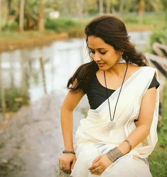 Woman in a Kerala saree sitting near the river HD wallpaper