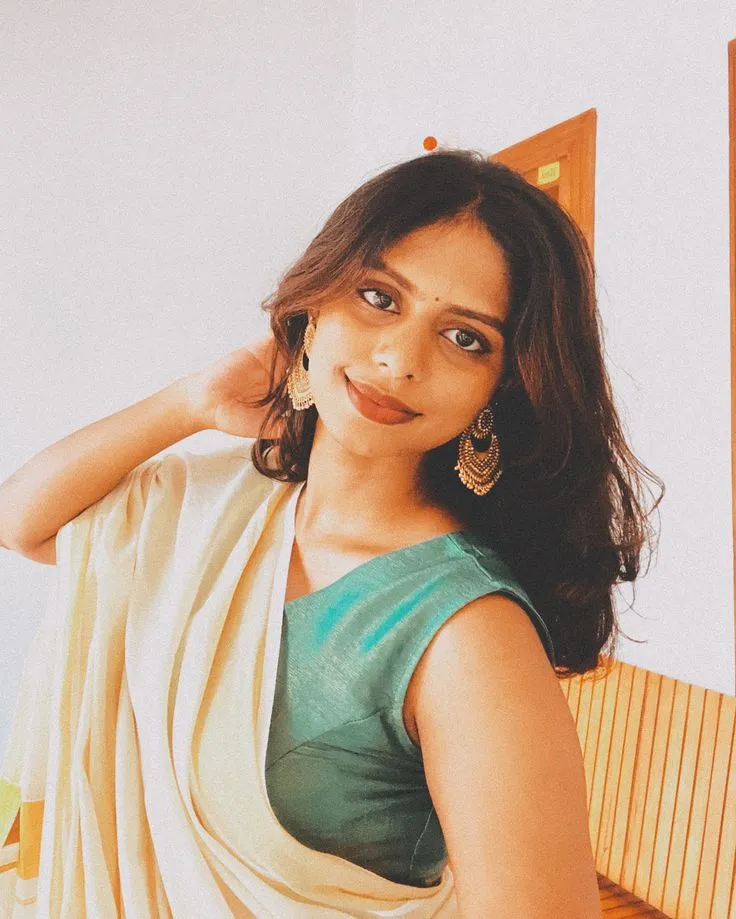 woman in a white saree and looking at the camera wallpaper