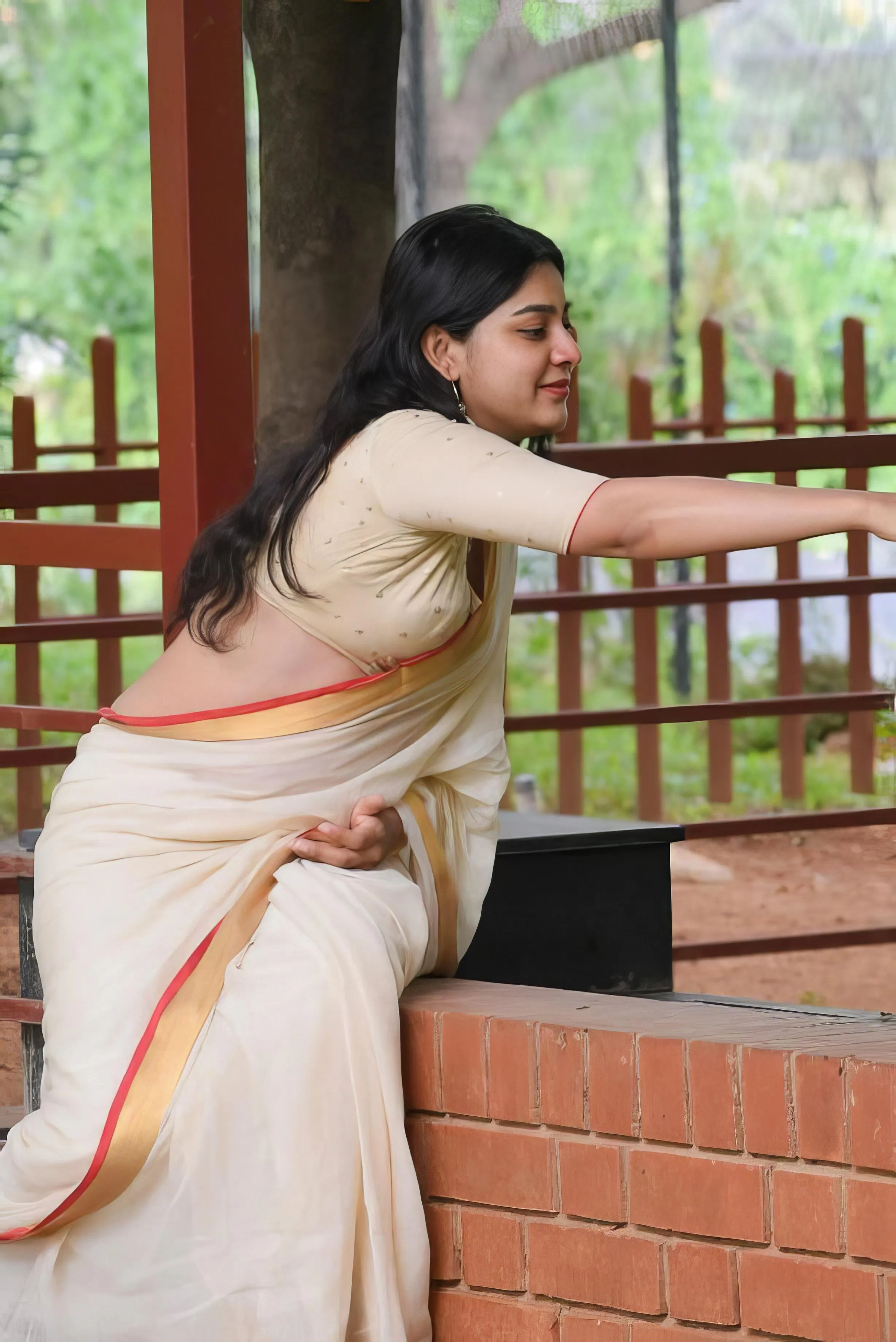 Woman in Cream Saree Leaning on Balcony with Elegance Image