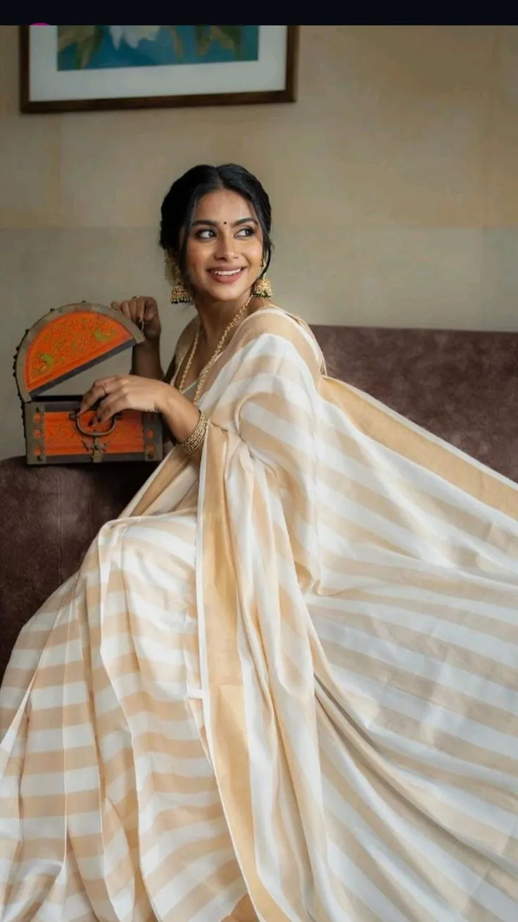 woman in striped cotton saree sitting on the sofa wallpaper