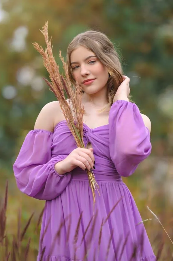 Woman in a Lavender Dress Holding Wheat in a Natural Setting