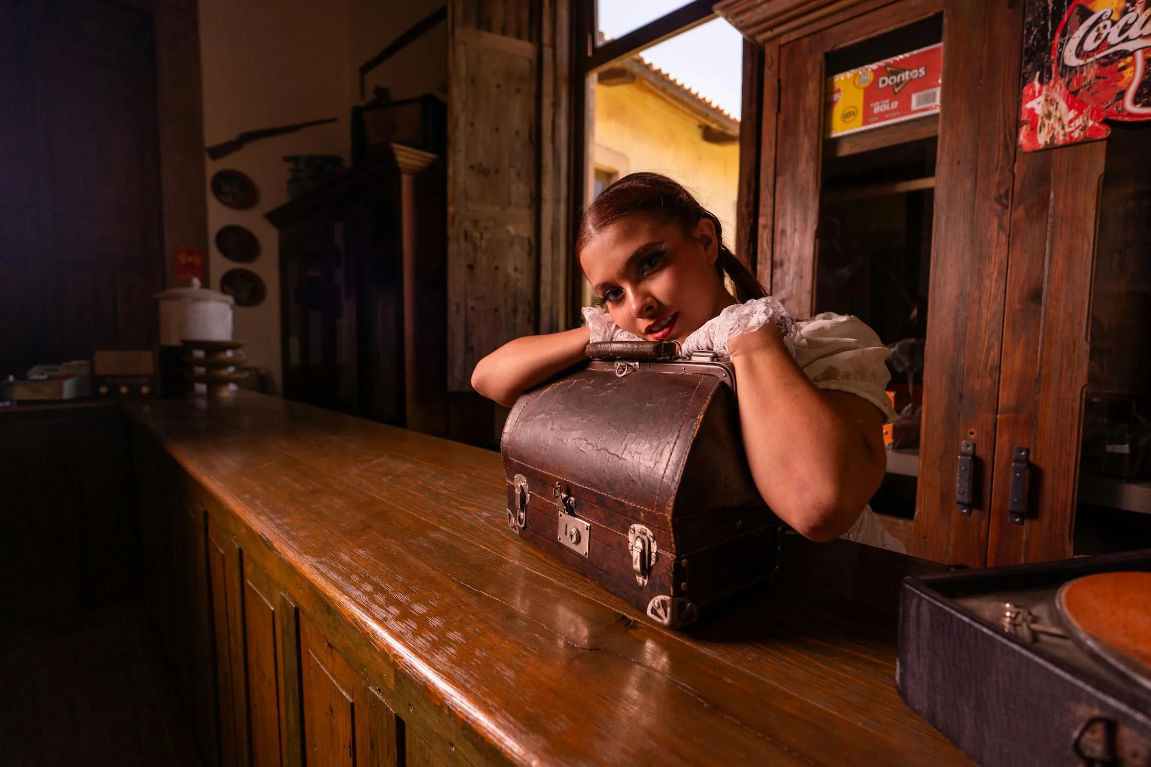 Woman Leaning on a Counter in a Dimly Lit Rustic Interior