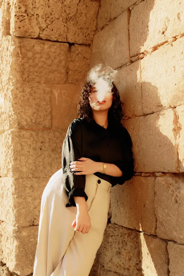 Woman Leaning on a Stone Wall in Cream Pants and Jacket