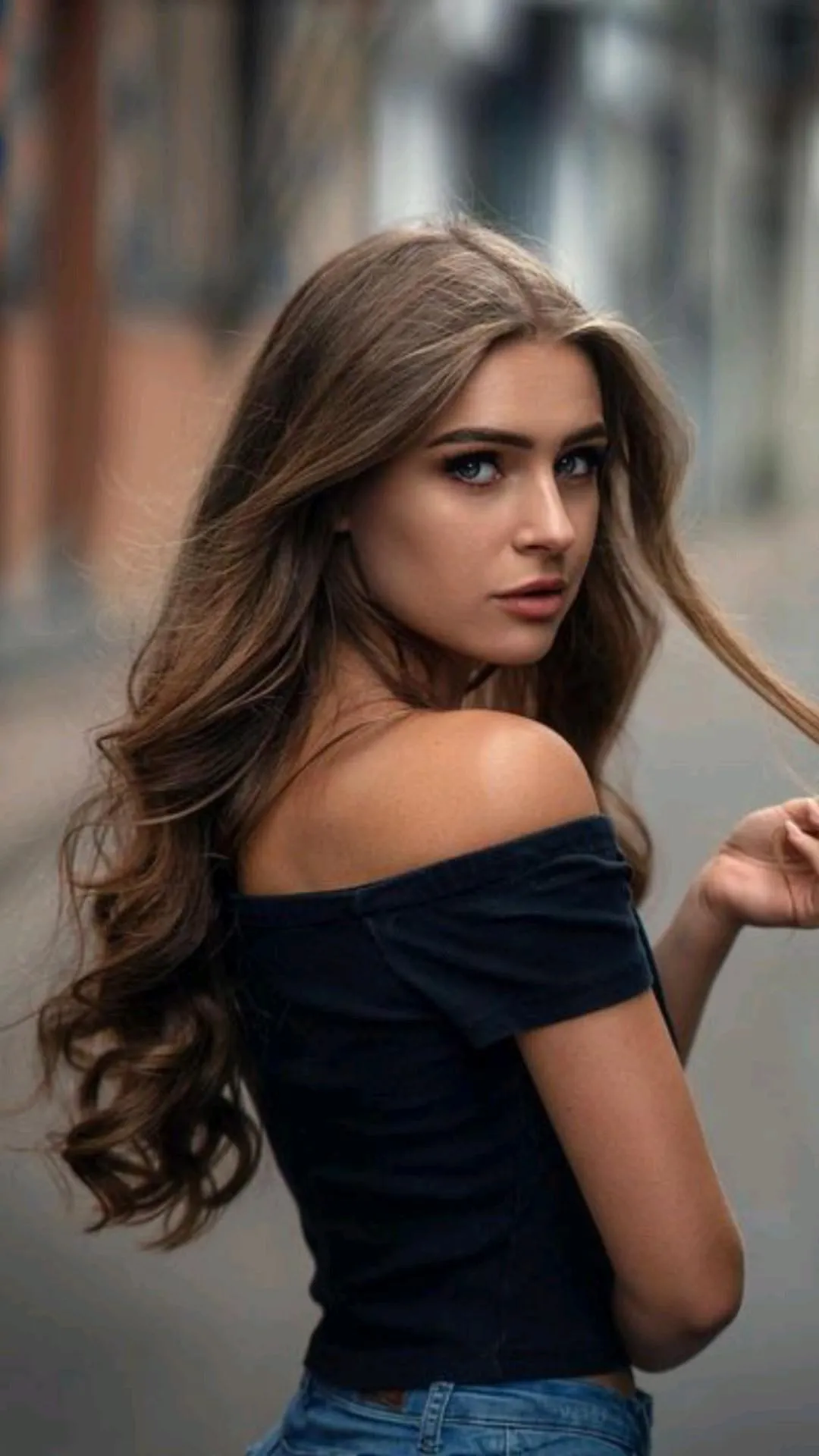Woman with Long Hair in a Black Off Shoulder Top Posing