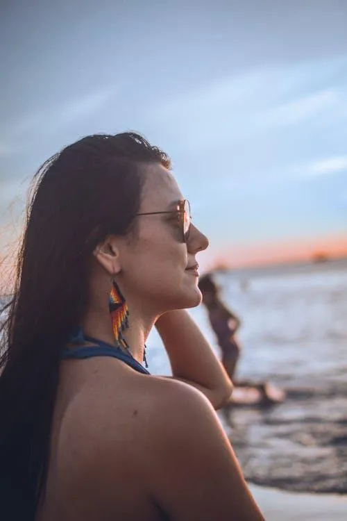 Woman Looking At the Ocean During Sunset Wearing Earrings