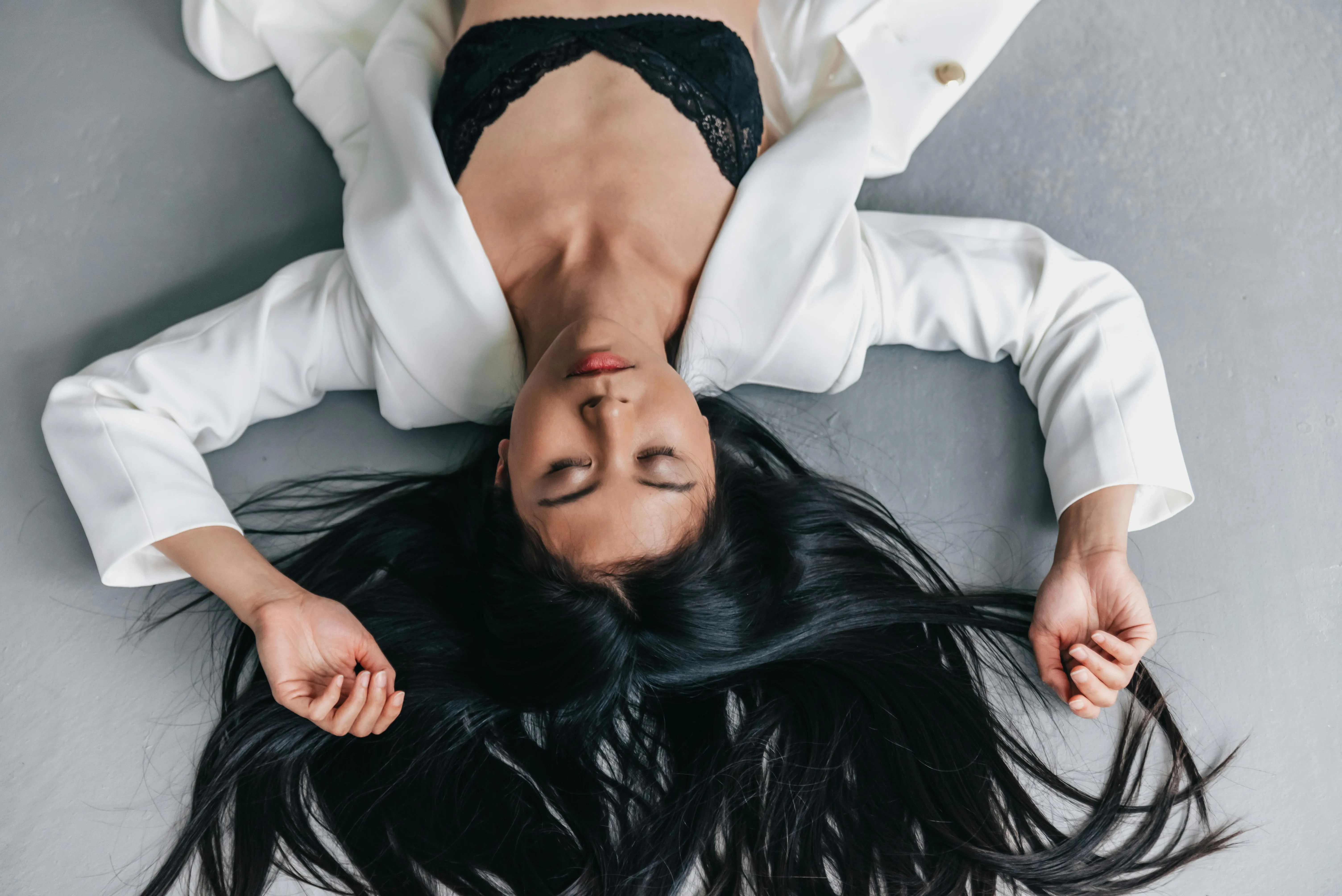 Woman Lying on Floor Holding Her Long Black Hair Wallpaper