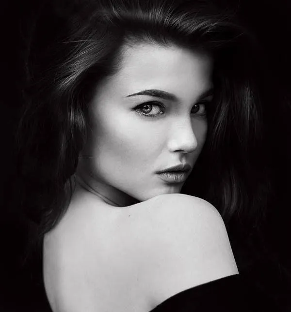 Woman Lying in Flowers Smiling with Arms Above Her Head