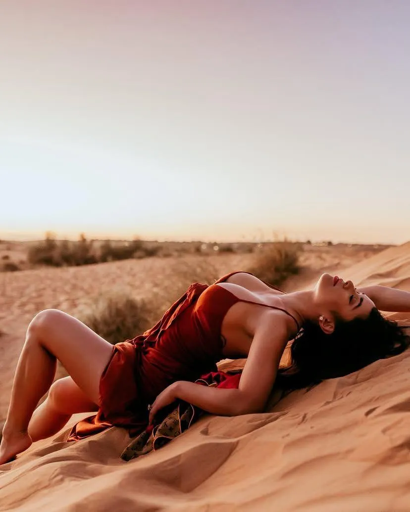 Woman Lying on the Desert Sand During Golden Hour Lighting