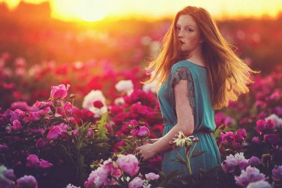 Woman in a Magenta Skirt Sitting Near Bright Pink Flowers