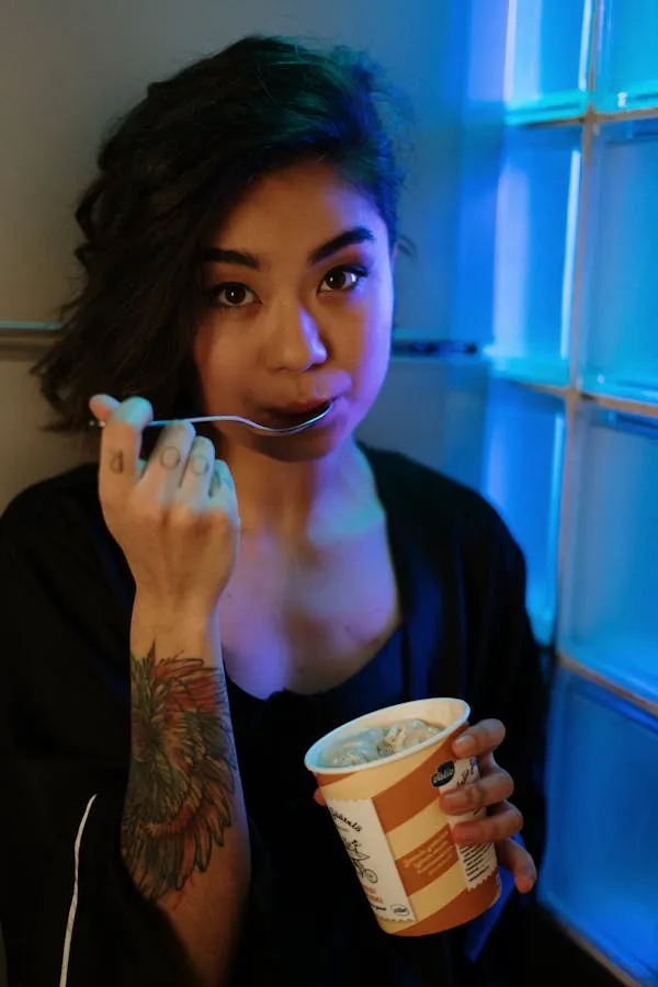 Woman Model Eating Ice Cream in a Neon Light Window At Night