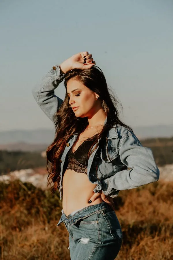 Woman Model Posing Outdoors Wearing a Denim Jacket and Jeans