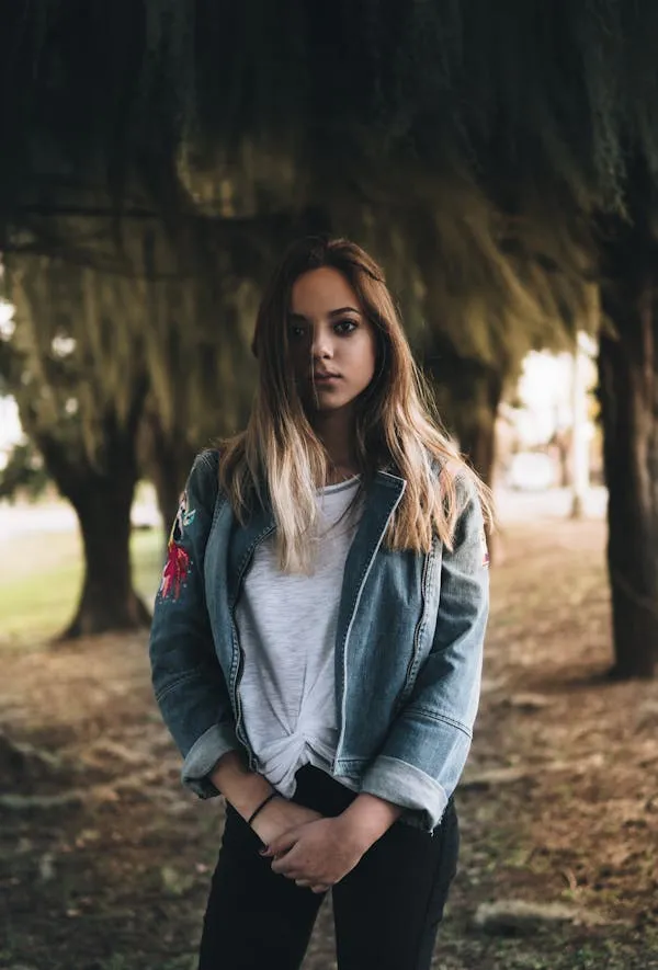 Woman Model Standing Outdoors with Trees and Soft Lighting