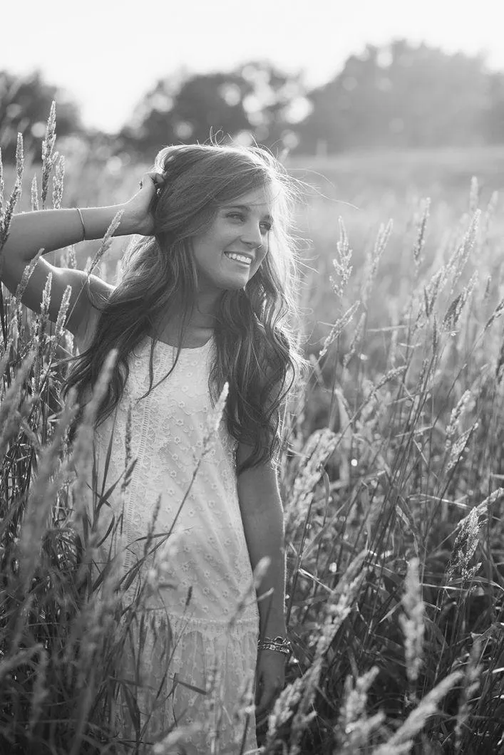 Woman Model Standing in a Sunlit Field Looking To the Side