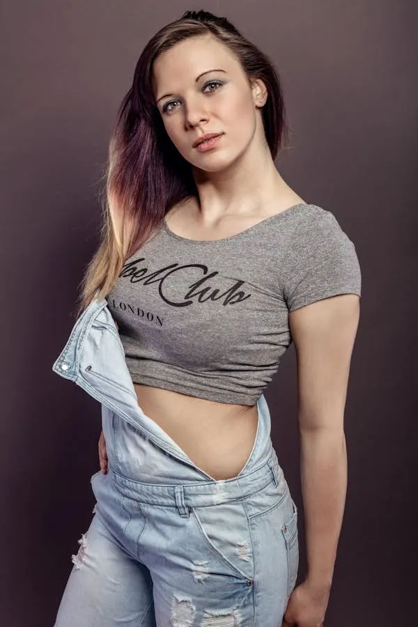 Woman in Overalls with Purple Hair Posing Against a Wall