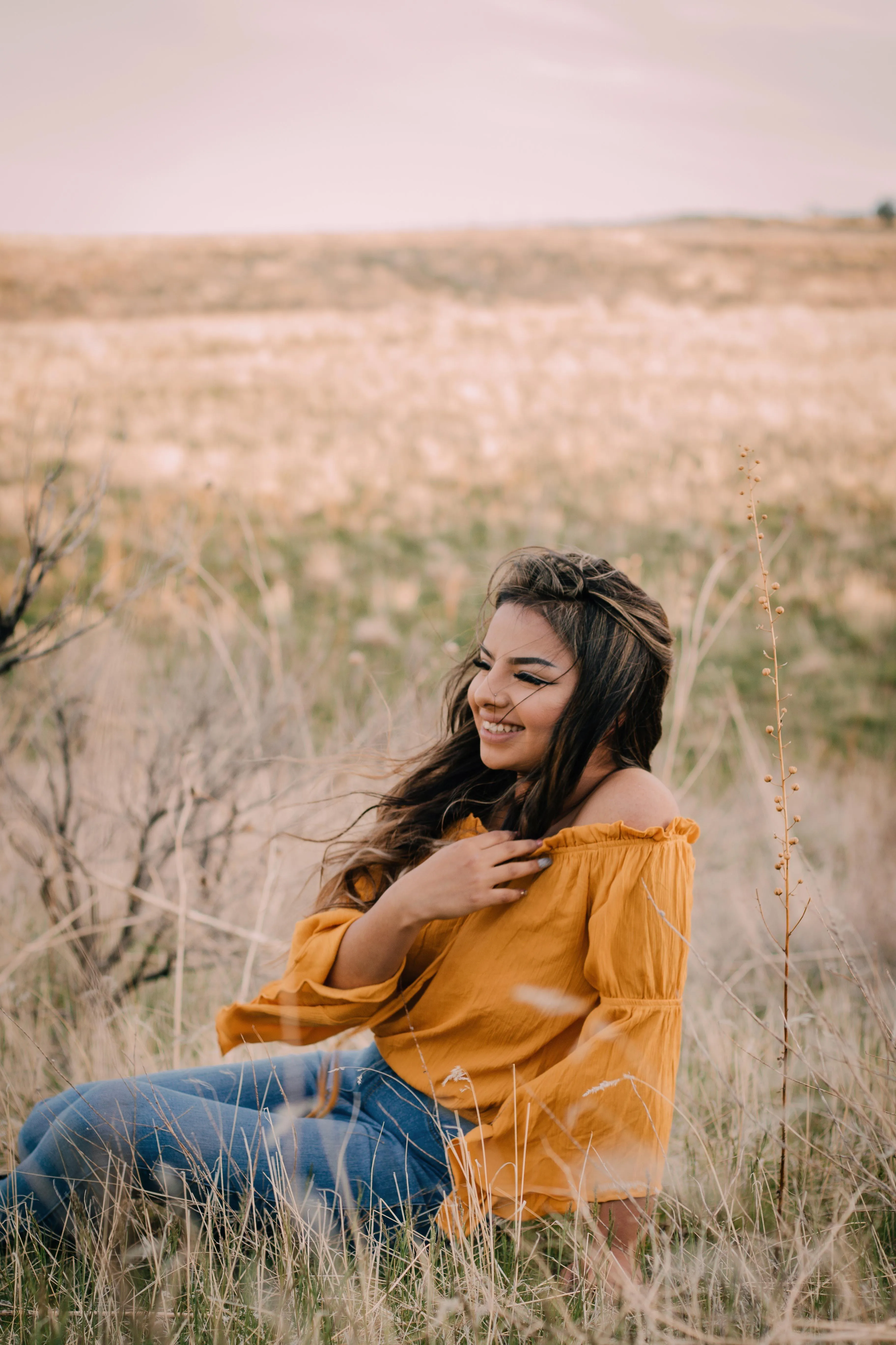 Woman in a Pink Dress Sitting on a Stone Wall in Daylight