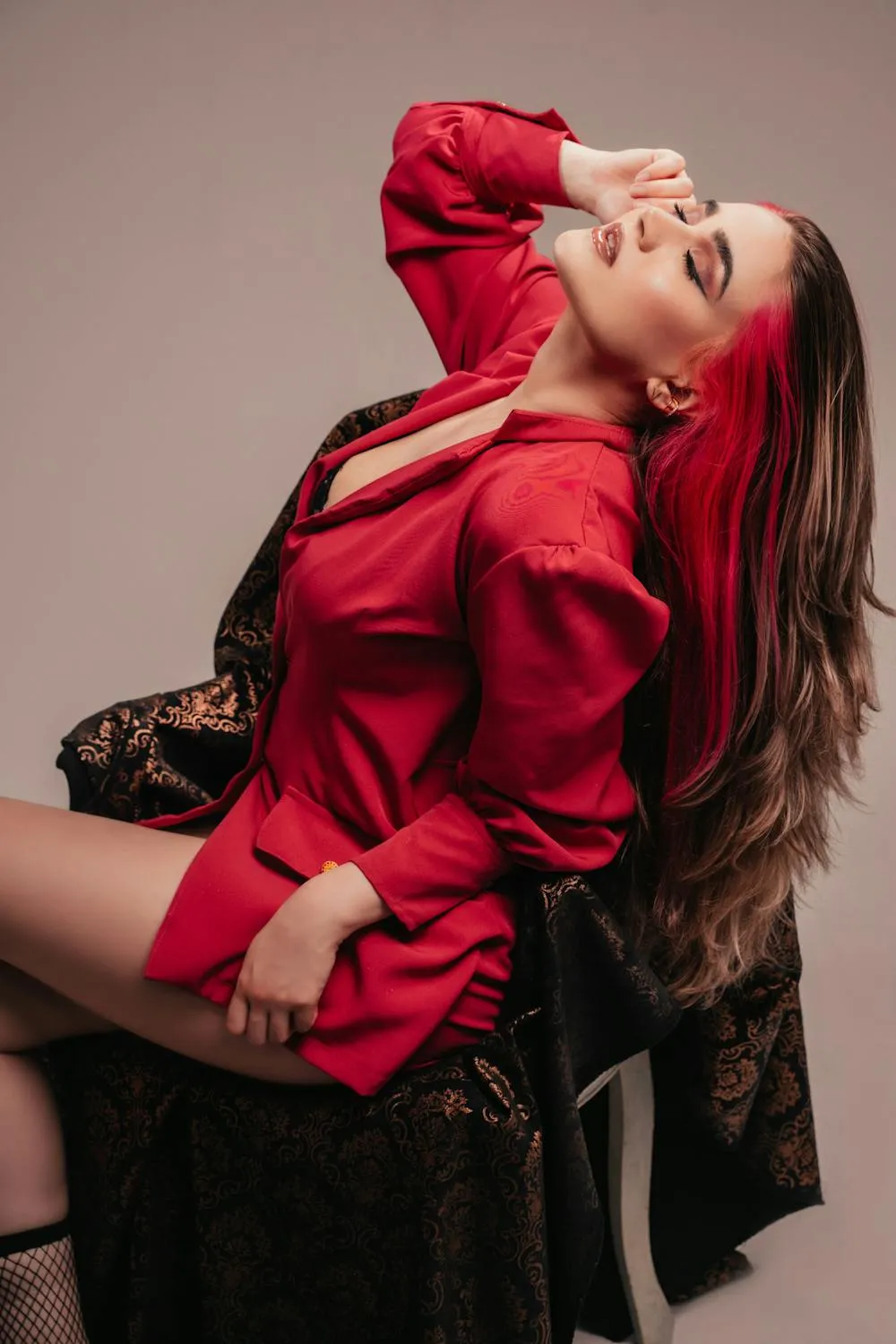 Woman with Pink Hair in Red Dress Posing Near Pink Backdrop